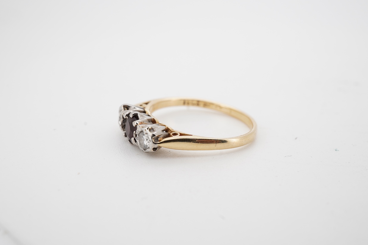 An early 20th century 18ct and plat. single stone garnet and two stone illusion set diamond ring, size J.